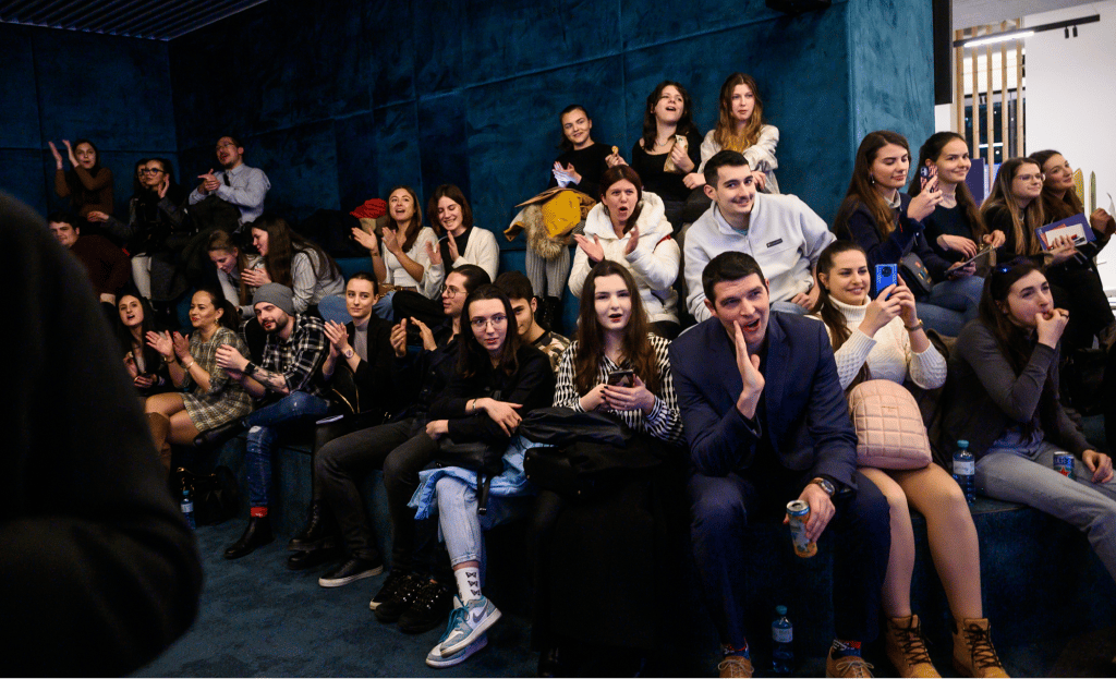Black and white photograph of people in a room, some seated.