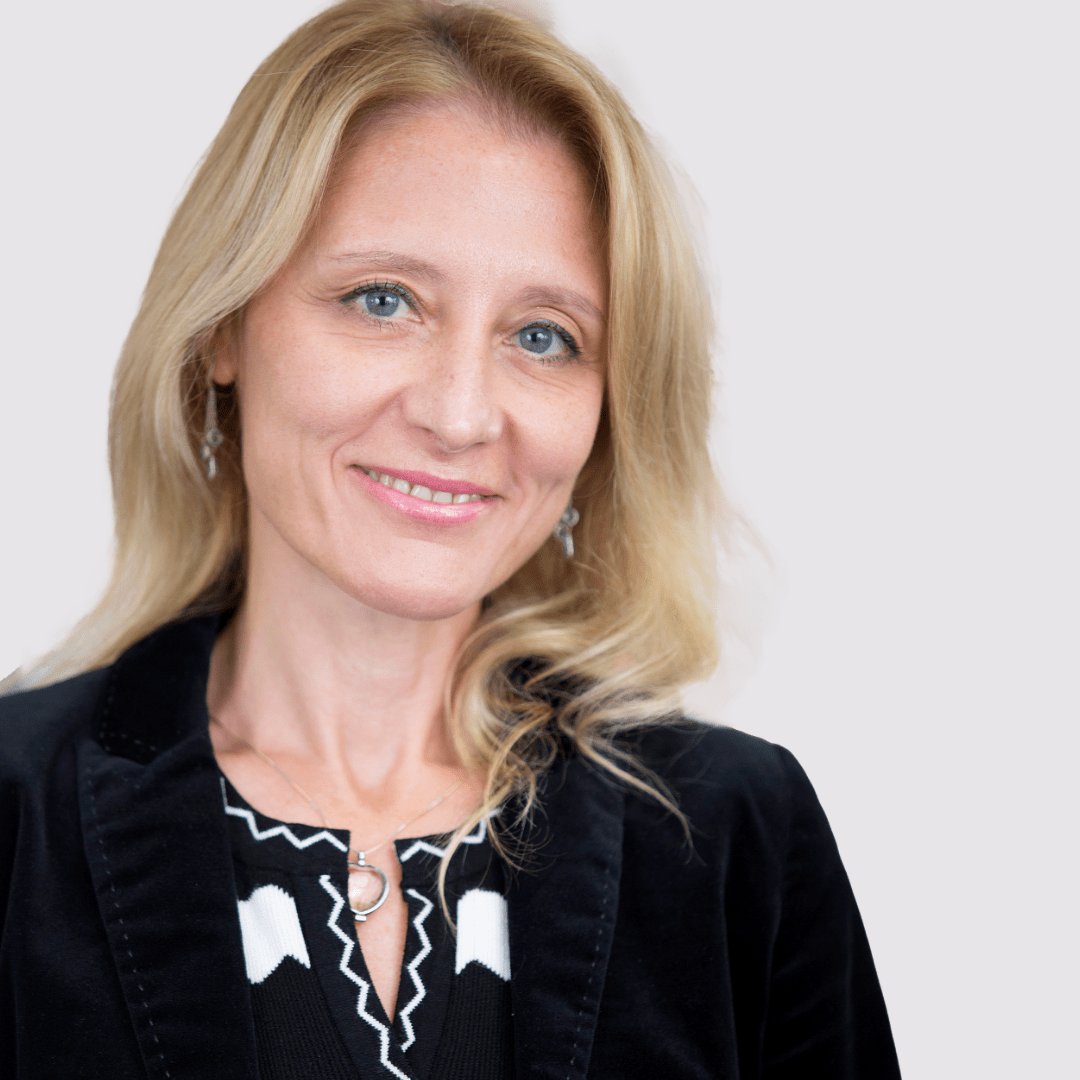 Portrait photograph of a woman with long hair, smiling.