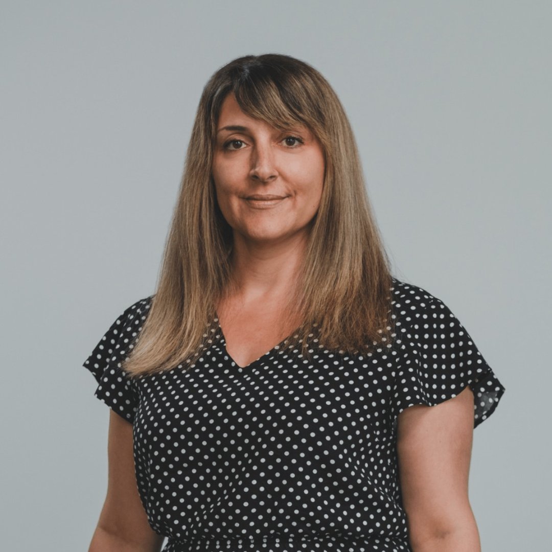 Portrait photograph of a woman with long hair, smiling.
