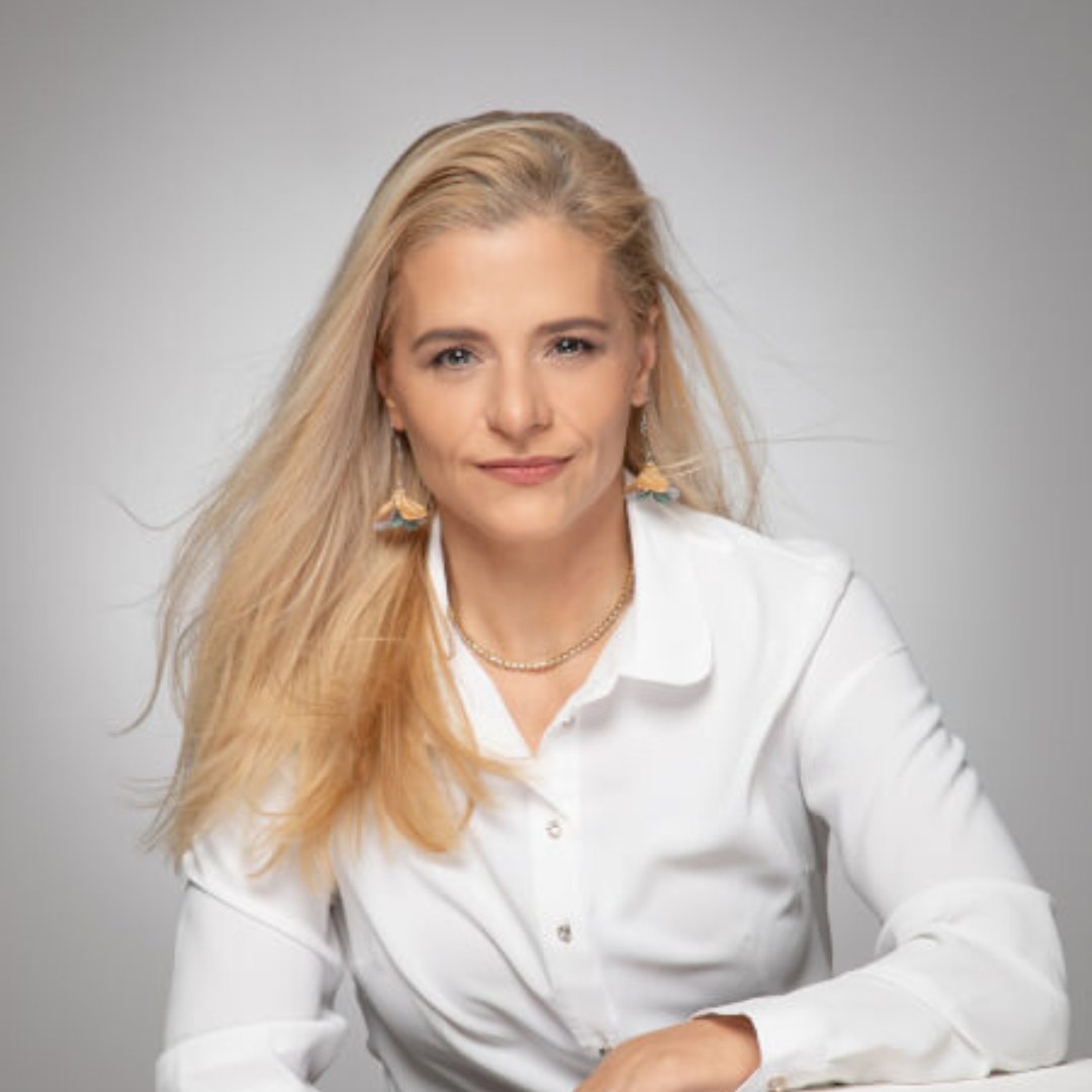 Portrait photograph of a woman with long hair, smiling.