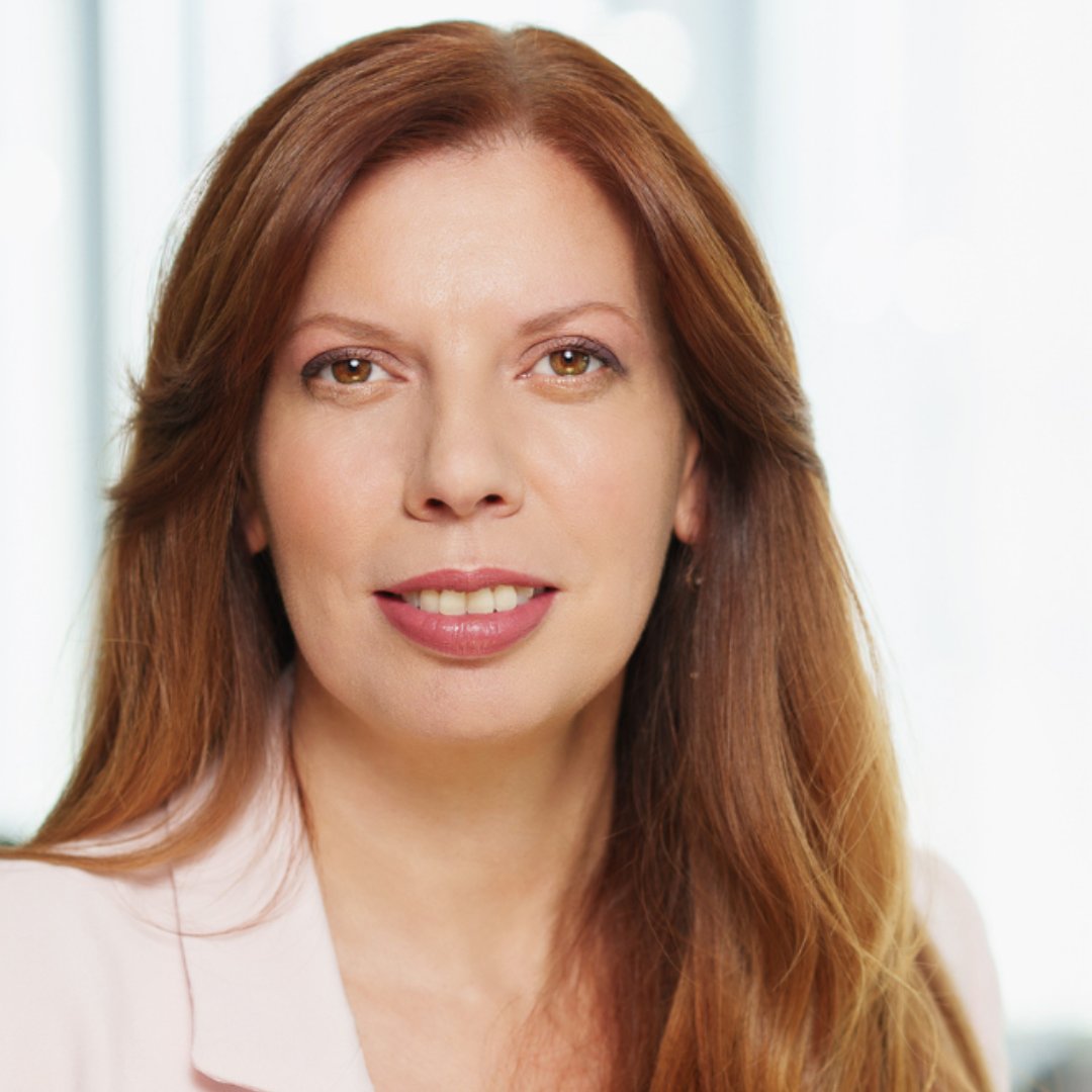 Portrait photograph of a woman with long hair, smiling.
