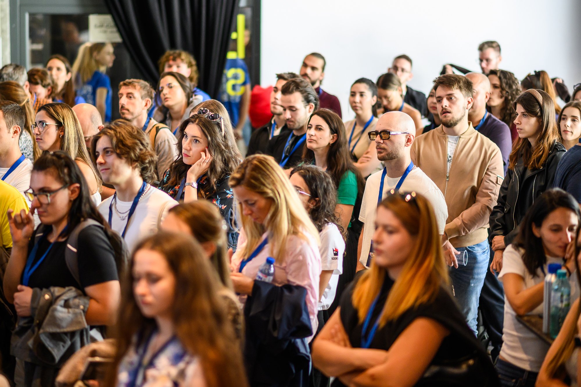 Medium shot photograph of two individuals talking, with a sign in background.
