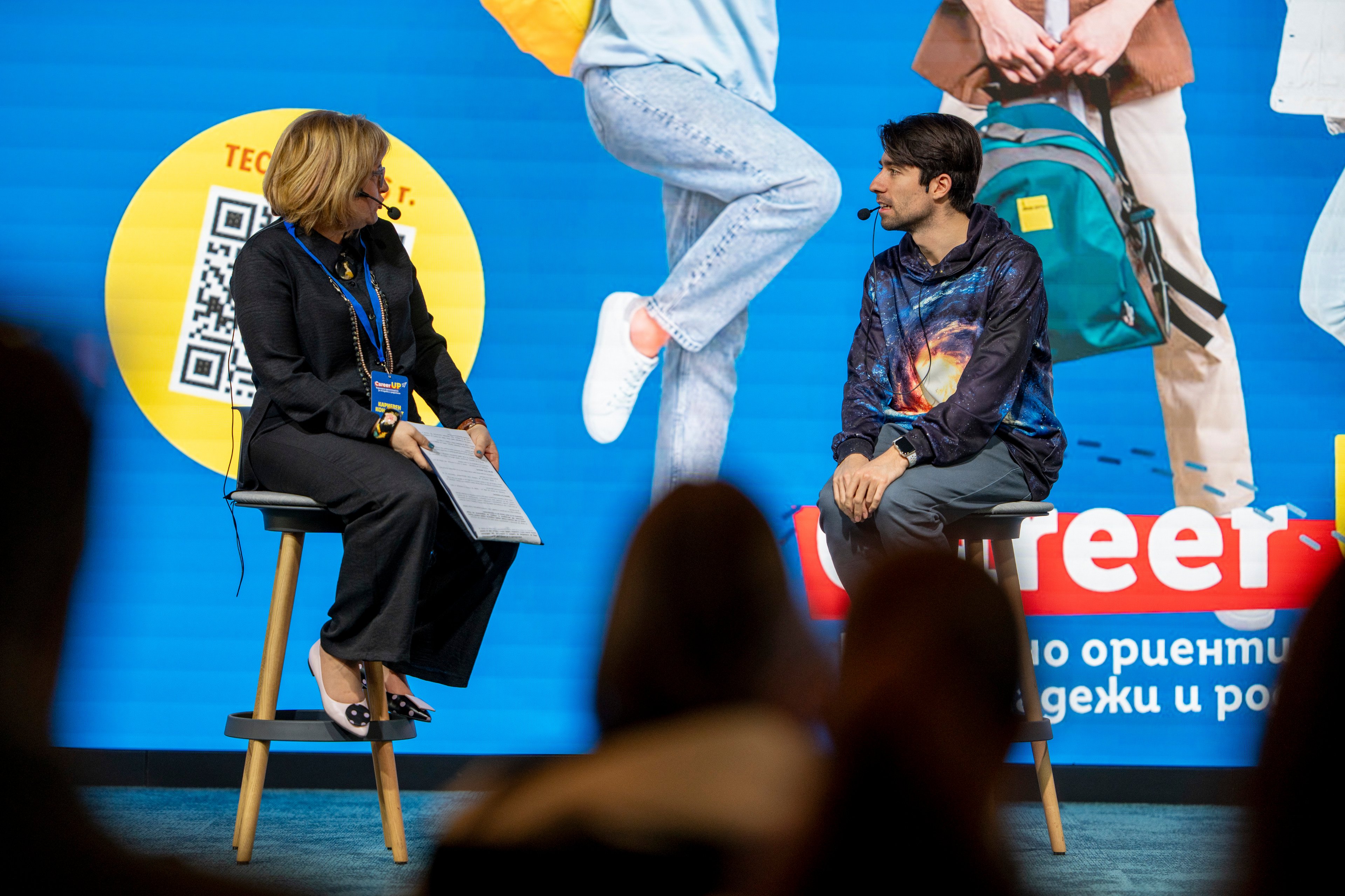Three people talking in front of a Commerzbank display.