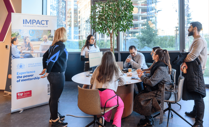 Black and white photograph of people in a meeting room setting.
