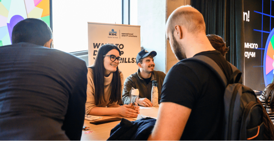 Black and white photograph of people at a table, some looking at papers.