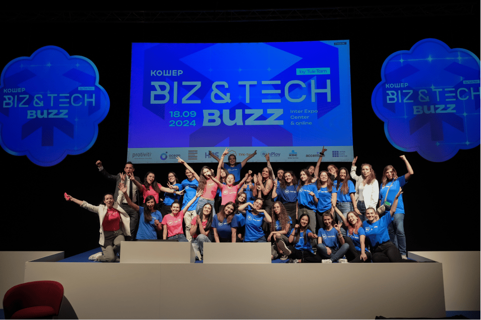 Wide-angle photograph of a large group of people posing on a stage.